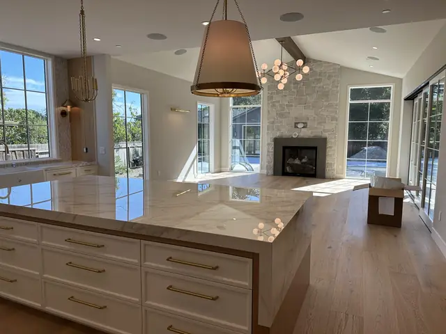 Bright open kitchen with a large island, pendant light and fireplace