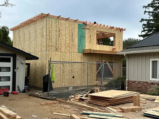 Two-story wood framing going up next to an existing house